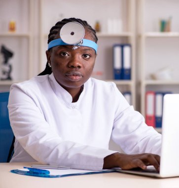 Klinikte çalışan siyahi kadın doktor.