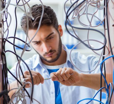 Elektrik teknisyeni tamir konseptinde kabloları çözmeye çalışıyor.