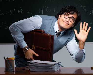 Tahtanın önündeki genç matematik öğretmeni.