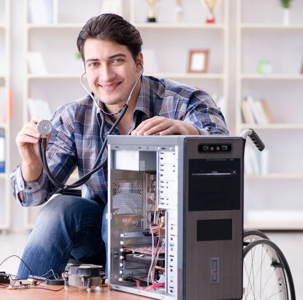 The disabled man on wheelchair repairing computer