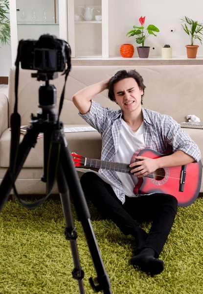 The young guitar player recording video for his blog