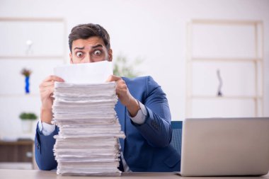Genç bir çalışan ve ofiste çok fazla iş var.