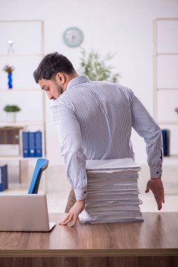 Genç işadamı ve işyerinde çok fazla iş var.