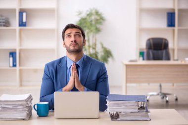 Genç işadamı ve işyerinde çok fazla iş var.