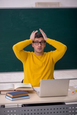 Sınıfta oturan genç öğrenci.