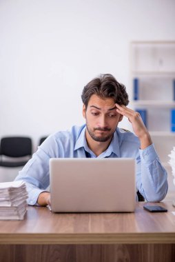 Genç işadamı ve ofiste çok fazla iş var.