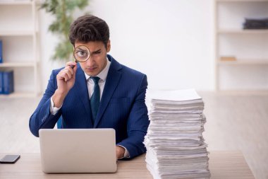 Genç işadamı ve işyerinde çok fazla iş var.