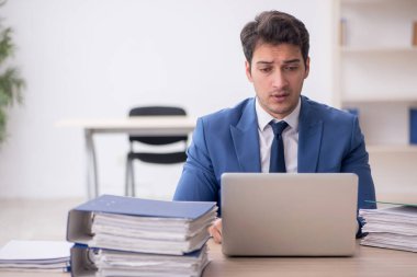 Genç işadamı ve işyerinde çok fazla iş var.
