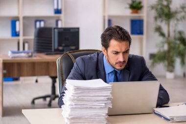 Genç işadamı ve ofiste çok fazla iş var.