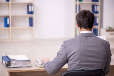 Genç işadamı işyerinde oturuyor.