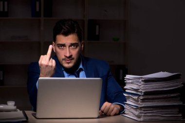 Young employee working late at workplace
