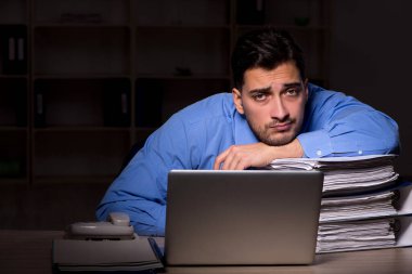 Young employee working late at workplace