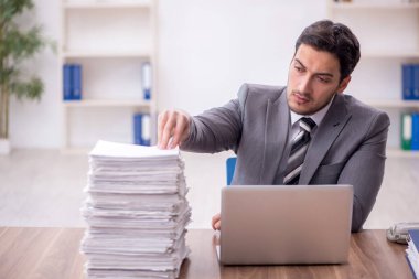 Genç bir çalışan ve ofiste çok fazla iş var.