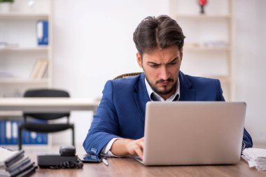 Genç işadamı ve ofiste çok fazla iş var.