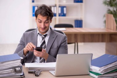 Ofisteki aşırı işten memnun olmayan genç bir çalışan.