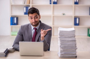 Young employee and too much work at workplace