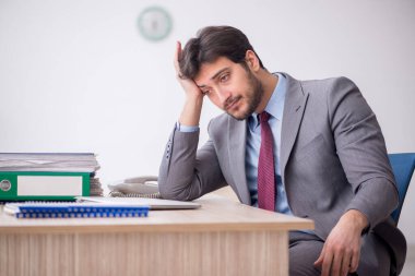 Young employee unhappy with excessive work at workplace