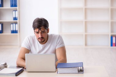 Genç çalışan serbest çalışan ofiste oturuyor.