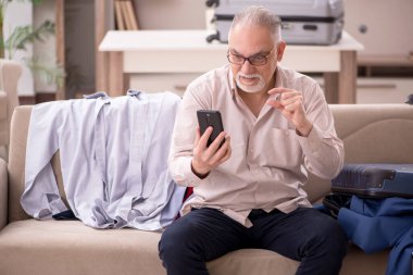 Aged man preparing for trip at home