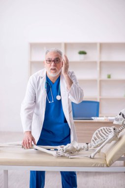 Old male doctor and skeleton patient at the hospital