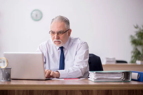 Stock image Old employee sitting at workplace