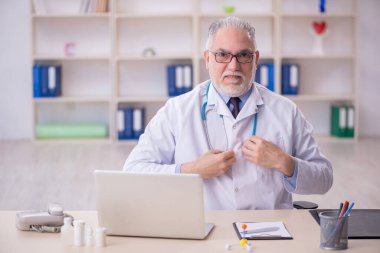 Klinikte çalışan yaşlı bir doktor.