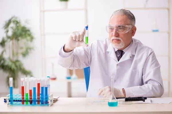 Old chemist working in the lab