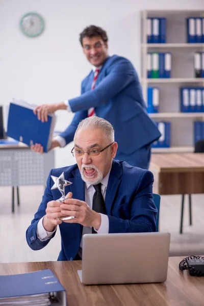 Two male employees with star award in the office
