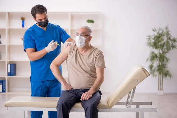 Old Patient Visiting Young Male Doctor Vaccination Concept — Stock Photo, Image