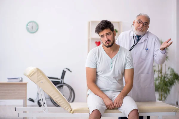 Genç Hasta Yaşlı Erkek Doktoru Ziyaret Ediyor — Stok fotoğraf