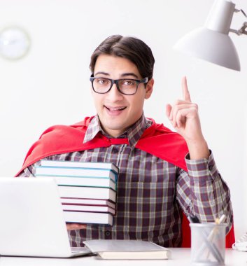 Dizüstü bilgisayarı olan süper kahraman öğrenci sınavlara hazırlanıyor.