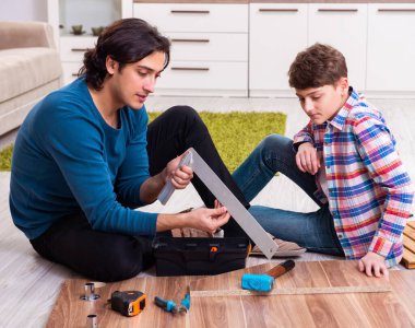 Genç marangoz oğluna öğretiyor.