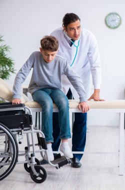Genç erkek doktor pediatrist ve tekerlekli sandalyedeki çocuk.