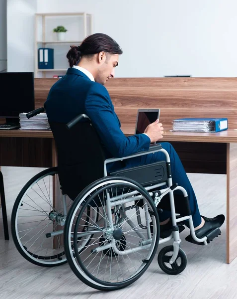 The young male employee in wheel-chair