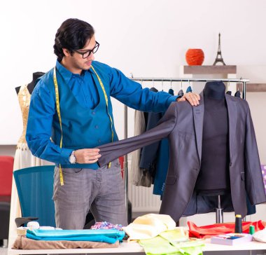 Atölyede çalışan genç erkek terzi.