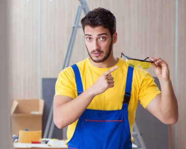 Genç tamirci marangoz odun kesiyor.