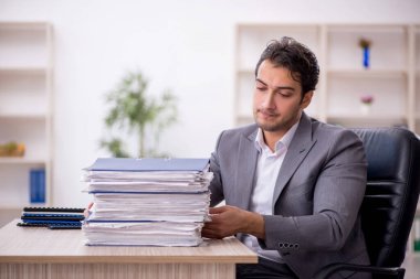 Genç işadamı ve ofiste çok fazla iş var.