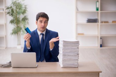 Ofiste kredi kartı tutan genç bir çalışan.