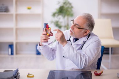 Klinikte çalışan yaşlı bir kardiyolog.