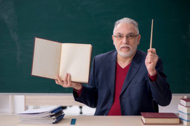 Old teacher sitting in the classroom