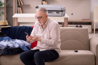 Aged man preparing for trip at home