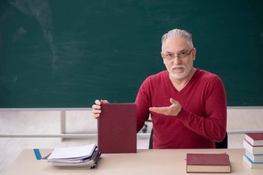 Old teacher sitting in the classroom