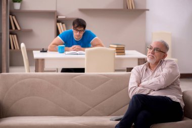 Young student and his grandfather at home