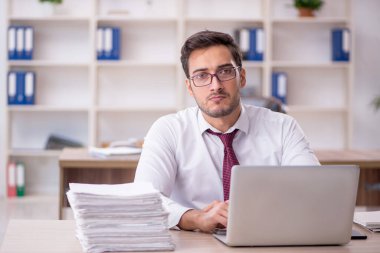 Genç işadamı işyerinde oturuyor.