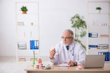 Hastanede çalışan yaşlı erkek dişçi.