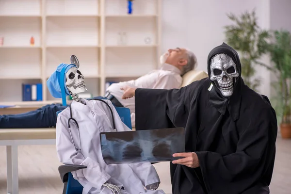 Two Devil Doctors Examining Old Patient — Stock Photo, Image