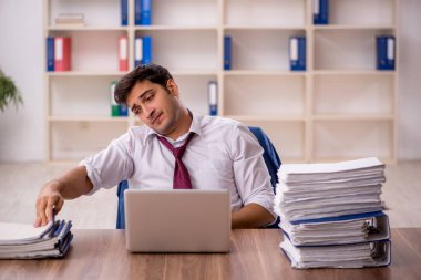 Genç işadamı ve ofiste çok fazla iş var.