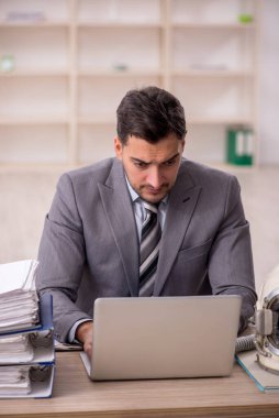 Young businessman employee wearing spacesuit at workplace