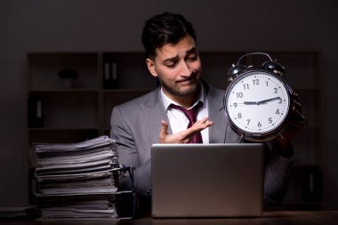 Young employee working late at workplace