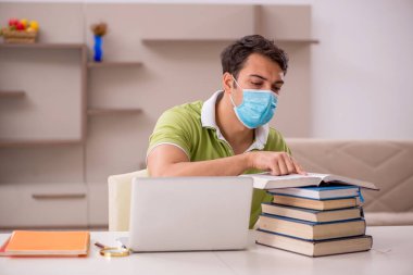 Genç öğrenci salgın sırasında evde sınavlara hazırlanıyor.